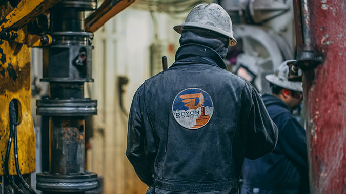 Drilling rig worker wearing a Doyon Drilling jacket.